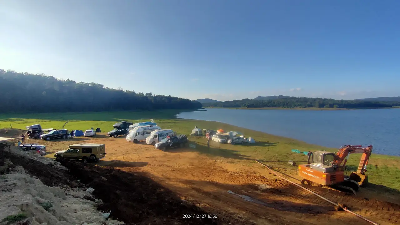 A wide view of the Harangi reservoir with the OAI convoy camped along the shore