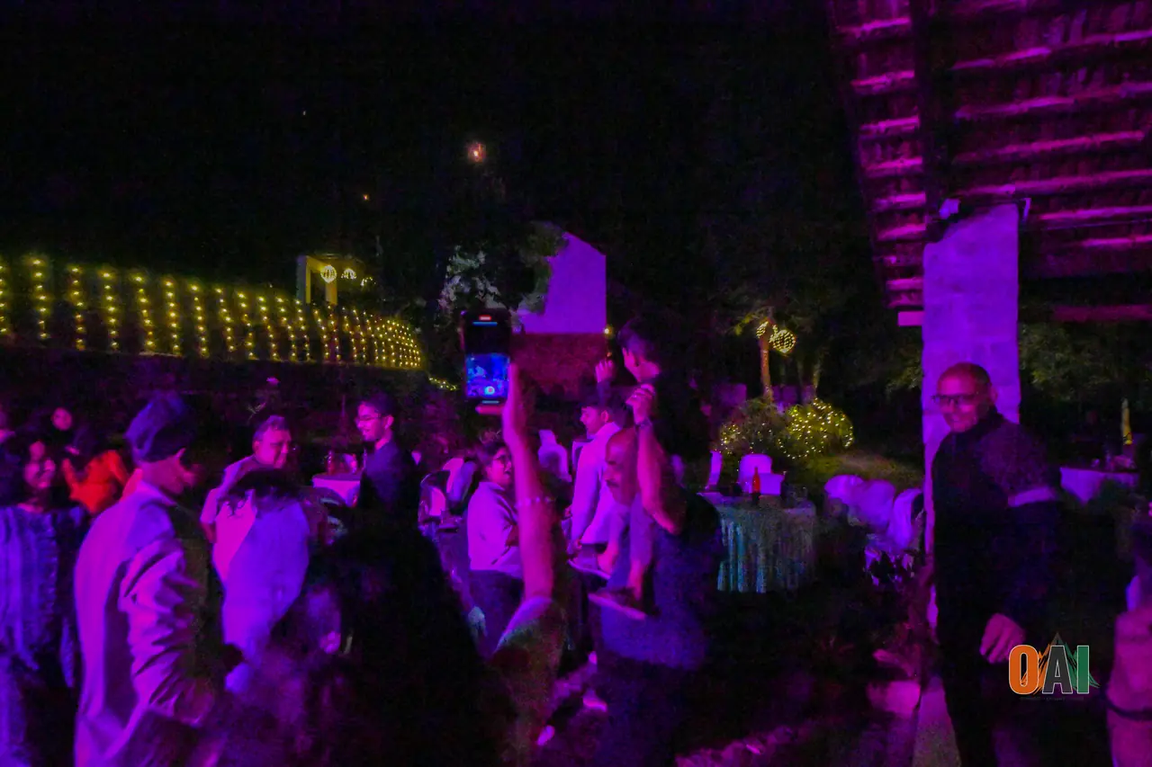 OAI members celebrating New Year's Eve under string lights at the Kushalnagar resort